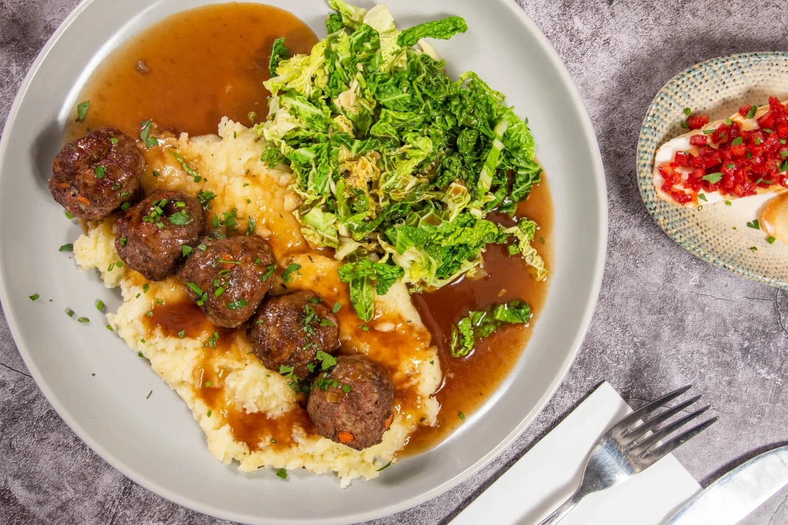 Meatballs with mashed potatoes, greens and gravy